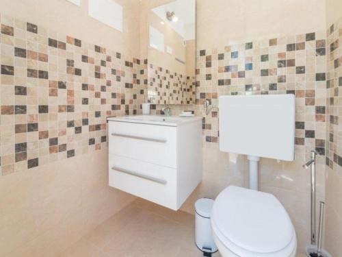 a bathroom with a toilet and a sink at Holiday Home Marin AS with Pool in Trbounje