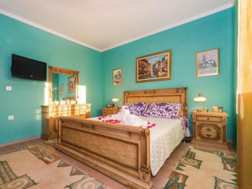 a bedroom with a large bed with blue walls at Holiday Home Marin AS with Pool in Trbounje