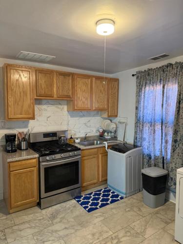 a kitchen with a stove and a sink at Comfortable 3-BR Home Minutes From UB South & Shop in Buffalo