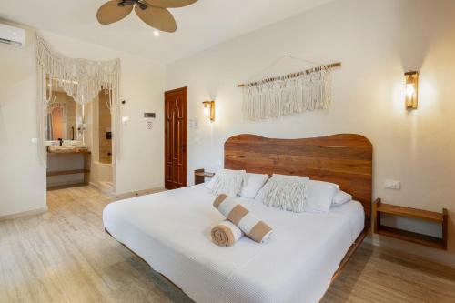 a bedroom with a white bed with two pillows on it at Casa Wayra Tulum - Boutique Condos in Tulum