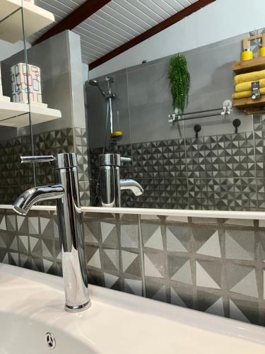 a bathroom sink with a faucet and a mirror at Tilys lodge in Capesterre-Belle-Eau