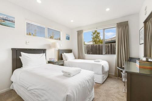 ein Hotelzimmer mit zwei Betten und einem Fernseher in der Unterkunft Amazing Location! Central 2 bedroom Unit in Wanaka