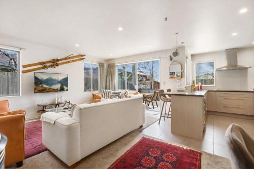 ein Wohnzimmer mit Couch und Küche in der Unterkunft Amazing Location! Central 2 bedroom Unit in Wanaka