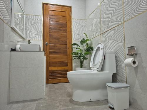 een badkamer met een toilet en een plant erin bij Casa Phangan in Wok Tum