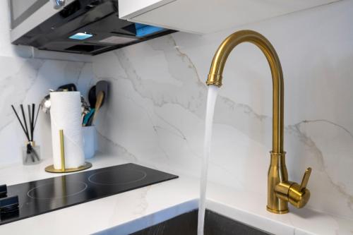 a kitchen sink with water running from a faucet at New Studio with Private Terrace and Volcano Bay view 5 min EPIC parking free in Orlando
