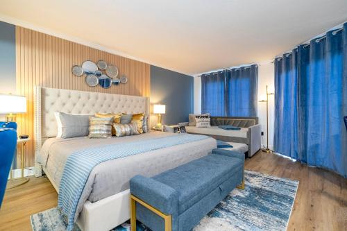 a bedroom with a large bed and blue curtains at Studio with Private Terrace and Volcano Bay View Near Epic Universe in Orlando