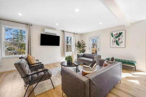 a living room with a couch and a tv at Spacious 5BR Home KING Bed Wi-Fi Parking in Bloomfield