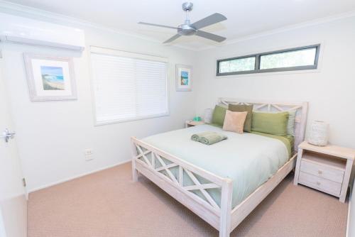 ein Schlafzimmer mit einem Bett und einem Deckenventilator in der Unterkunft Melaleuca Lookout - Pet Friendly in Point Lookout