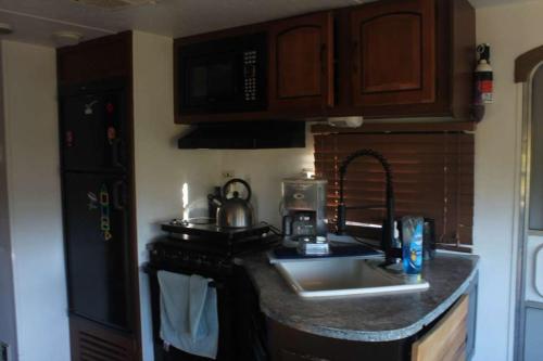 a kitchen with a sink and a counter top at Comfortable Guest RV With EV charger Semi Rural Area in Bodfish