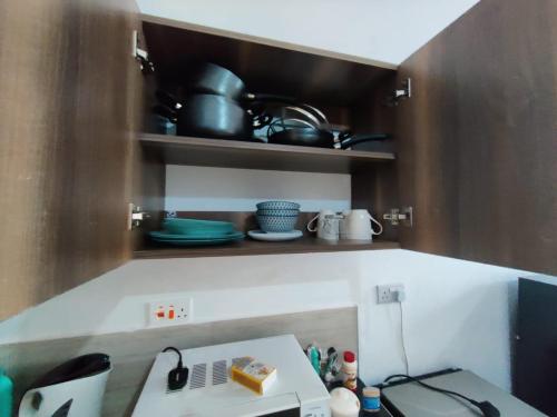 a kitchen with a sink and a microwave in it at Tee,s Homestay in Mtwapa
