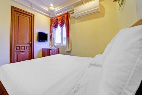 蒂鲁奇奇拉帕利Hotel O Royal的卧室里有一张白色的大床和一扇窗户