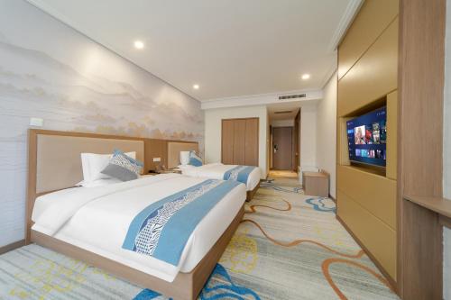 a hotel room with two beds and a flat screen tv at Days Inn Xi'an City Center in Xi'an