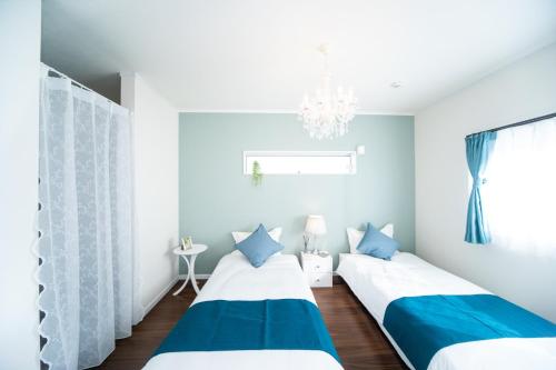 2 Betten in einem blau-weißen Zimmer in der Unterkunft Shizuki no Sato Tsuki Terrace 531 - Vacation STAY 98450v in Awaji