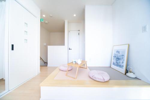 ein Wohnzimmer mit rosa Kissen und einem Tisch in der Unterkunft Shizuki no Sato Tsuki Terrace 531 - Vacation STAY 98450v in Awaji