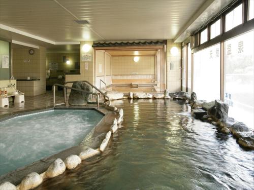 a large pool of water in a large room at 佐久一萬里温泉ホテル in Saku