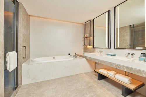 a bathroom with a tub and a sink at Delta Hotels by Marriott Jiuzhaigou in Jiuzhaigou