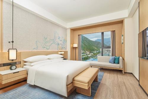 a bedroom with a large white bed and a window at Delta Hotels by Marriott Jiuzhaigou in Jiuzhaigou