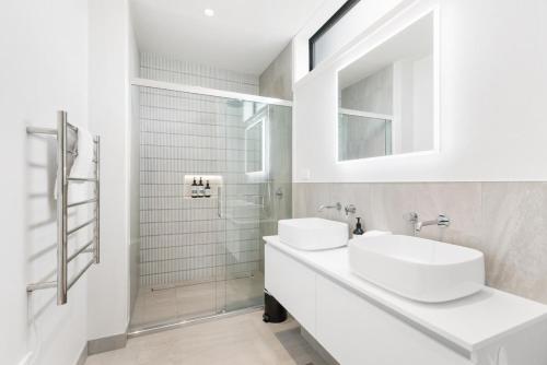 ein weißes Badezimmer mit zwei Waschbecken und einer Dusche in der Unterkunft Modern 3-Bed Villa with Mountain Views in Wanaka