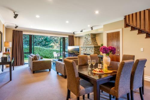 a dining room and living room with a table and chairs at Platinum Queenstown in Queenstown