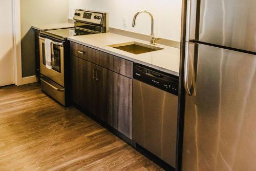 eine Küche mit einer Spüle und einem Kühlschrank aus Edelstahl in der Unterkunft The Spot Pet Friendly Furnished 3 Bedrooms Rental in Winnipeg 116 in Tuxedo