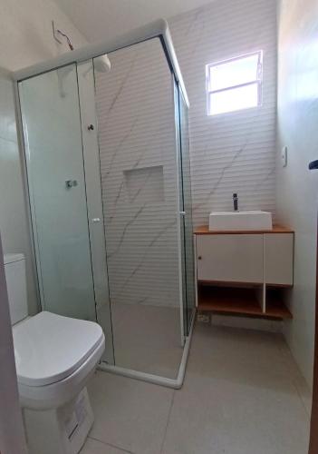 a bathroom with a shower and a toilet and a sink at Natal em Garanhuns, PE - Apartamento minimalista próximo ao Centro in Garanhuns