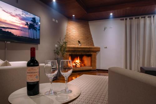 - une bouteille de vin assise sur une table avec 2 verres à vin dans l'établissement Pousada Portal da Serra, à Campos do Jordão