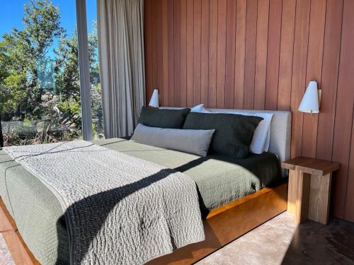 a bedroom with a bed and a large window at Red-tail Cabin at Gamenthaler in Fredericksburg