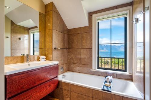 een badkamer met een bad en een raam bij Platinum Queenstown in Queenstown