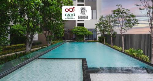 a swimming pool in front of a building at SureStay by Best Western Bangkok Ramintra in Bangkok