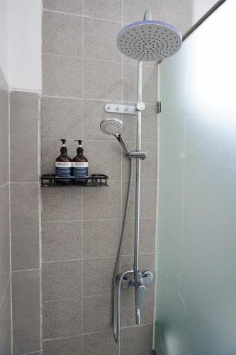 a shower with a shower head in a bathroom at Habitat Boutique Dive Resort in Tulamben