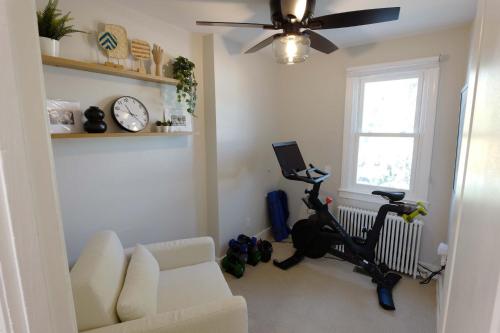 a living room with a couch and a chair and a treadmill at Stadium Armory Stay in Washington