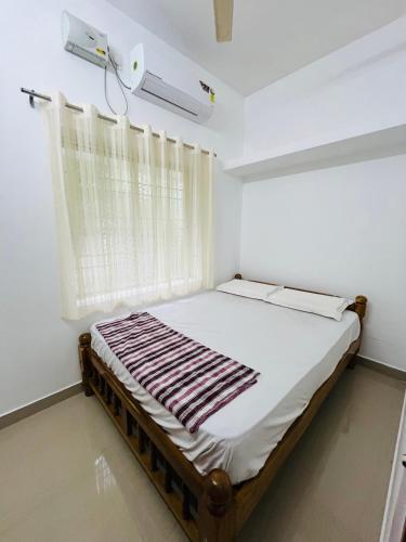 un lit dans une chambre avec une fenêtre dans l'établissement Manikya Homestay, à Malpe