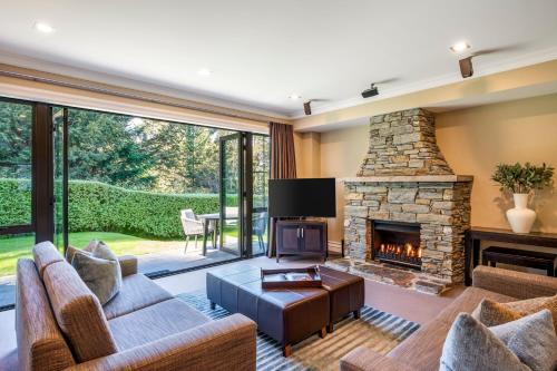 a living room with a couch and a fireplace at Platinum Queenstown in Queenstown