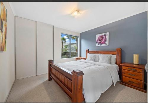 a bedroom with a large bed and a window at Cozy Water-View 2-Bdrm Suite in North Shore in Auckland