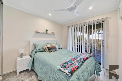 een slaapkamer met een bed met een groen dekbed bij 1-20 Bauer Street in Bargara