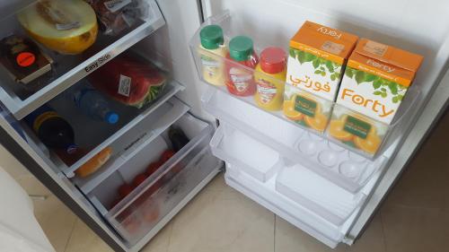 een open koelkast gevuld met veel eten en drinken bij Newcenter Suites in Tanger
