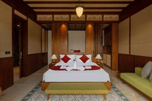 a bedroom with a large bed and a green couch at Nauma Ubud Villa in Ubud