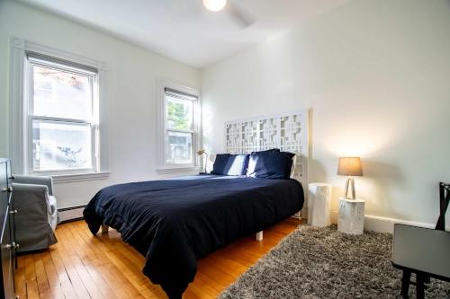 Un dormitorio con una cama grande y dos ventanas. en Cambridge Base Steps to Porter Square, en Old Cambridge
