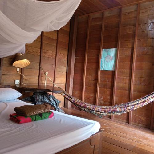 a bedroom with a hammock in a wooden wall at FamilyHouse & Trekking in Banlung