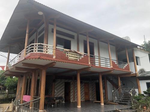 a house with a balcony on the side of it at Trần Sơn Homestay in Na Hang