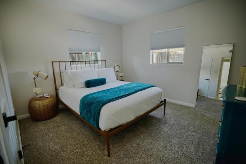 a bedroom with a bed with a blue blanket on it at The White House, A Unique ABQ Stay in Central Location near Uptown in Albuquerque