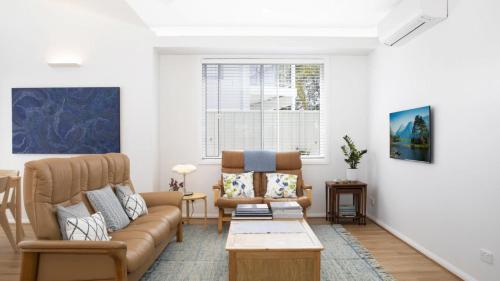 a living room with a couch and a table at Summer Splendor - Ettalong Beach in Ettalong Beach
