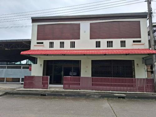 a building with a red awning on a street at Padang Besar Border Private room & Hostel in Sathani Padang Besa