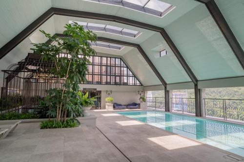 an indoor swimming pool with a large glass ceiling at Paxtonz Suites,1Utama,IKEA Damansara,SEGi,Desa Park in Petaling Jaya