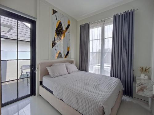 ein Schlafzimmer mit einem Bett und einem großen Fenster in der Unterkunft QueeNdra Villa in Tlekung