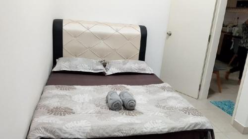 a bed with two pairs of shoes on it at Canopy Hill Kajang 2 in Kajang
