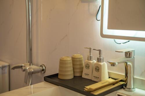 a bathroom sink with soap and toothbrushes on a tray at Háng Đồng Ecolodge in Bắc Yên