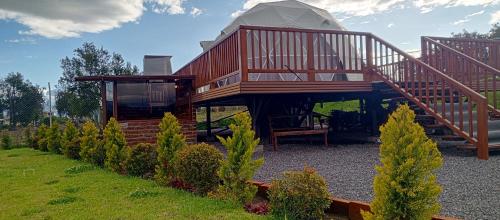 a gazebo with a staircase and a house at Domo glamping con jacuzzi y croquet in Latacunga