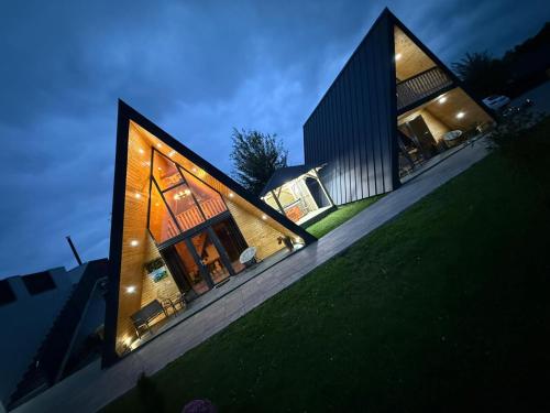 a house with lights on the side of it at A Frame Bâlea Chalet in Cîrţişoara