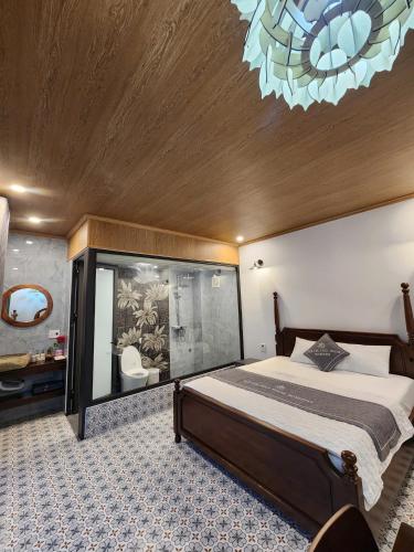 a bedroom with a large bed and a chandelier at Villa Full House in Vũ Lâm